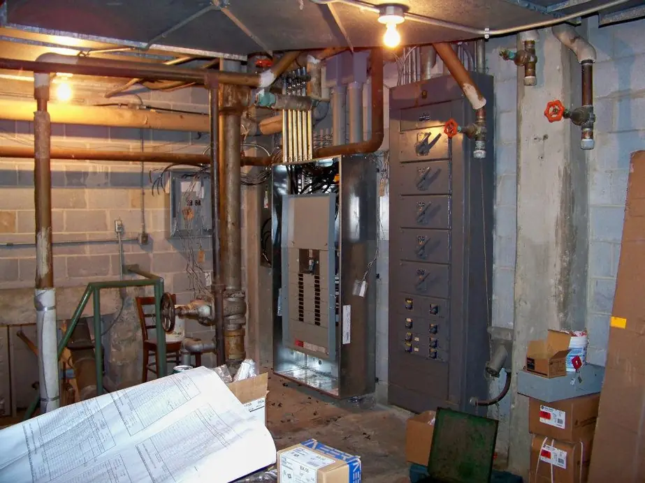 A mechanical room with an electrical distribution panel and copper piping