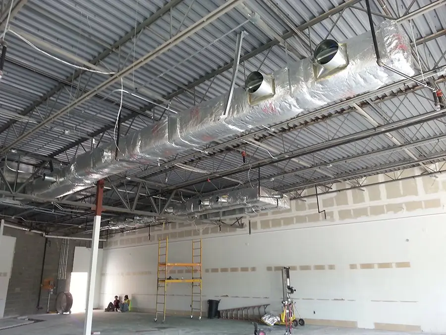 A long insulated duct run hung under steel trusses on a Richard Electric commercial job
