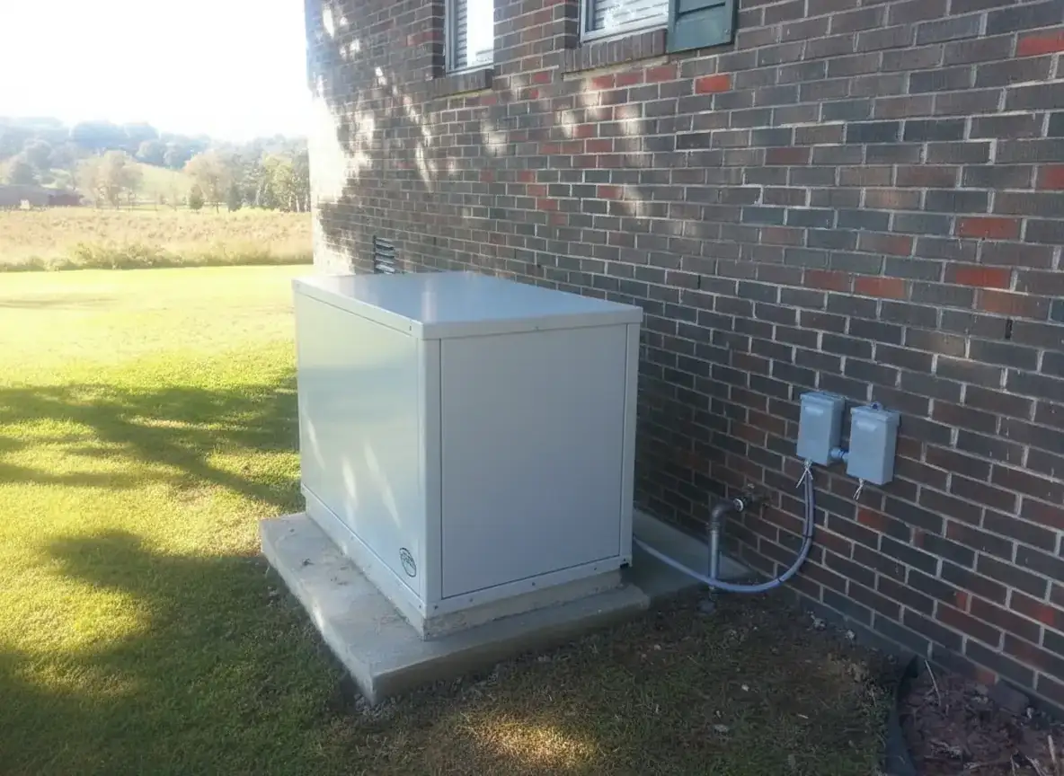 A home standby generator on a concrete pad beside a red-brick wall